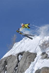 un esquiador saltando de una montaña cubierta de nieve en Hotel Negritella, en Passo del Tonale
