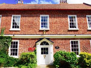 a red brick house with a white door at Wrangham House in Filey