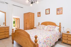 ein Schlafzimmer mit einem Holzbett und einer Kommode in der Unterkunft Ca Na Barbara in Santa Maria del Camí