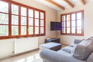 a living room with two couches and windows at Finca Can Pol in Inca
