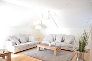 ein Wohnzimmer mit 2 weißen Sofas und einem Couchtisch in der Unterkunft Villa Ocean Place in Haffkrug