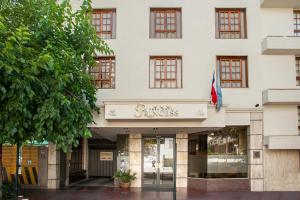 a facade of a white building with a flag at Hotel Princess in Mendoza