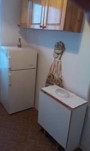 eine kleine Küche mit einem weißen Kühlschrank und einem Tisch in der Unterkunft Retro apartment in Malko Tŭrnovo