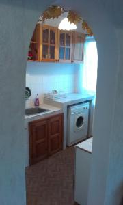 einen Torbogen in einer Küche mit Spüle und Geschirrspüler in der Unterkunft Retro apartment in Malko Tŭrnovo