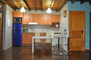 a kitchen with a table and a blue refrigerator at Suite rural Nido Azul in Benllera