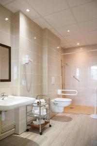 La salle de bains est pourvue d'un lavabo et de toilettes. dans l'établissement Hostellerie de La Roseraie, à Barbotan-les-Thermes