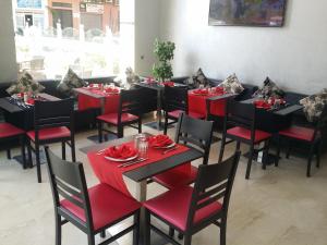 a dining room with black tables and red chairs at Hôtel Teranga & Spa in Marrakesh