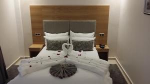 a bedroom with a white bed with a flower decoration on it at Hôtel Teranga & Spa in Marrakesh