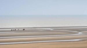a group of people riding horses on the beach at Rewindhotel in Oostduinkerke