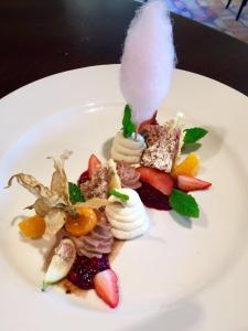 a white plate with a dessert with fruit on it at Landhotel Hirschen in Trüllikon