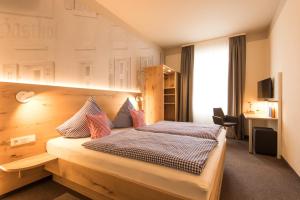 a bedroom with a large bed with a wooden headboard at Posthorn in Ühlingen-Birkendorf