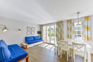 een woonkamer met een blauwe bank en een tafel bij Residence Cap Glenan - maeva Home in Bénodet