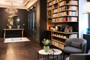 a living room with a large book shelf filled with books at H&ocirc;tel Square Louvois in Paris