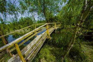 eine Holzbrücke über einen Wasserkörper in der Unterkunft Dunaiskaya Usadba in Wylkowe