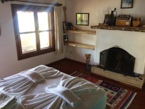 1 dormitorio con chimenea, 1 cama y ventana en Simena Pension, en Kaleucagız