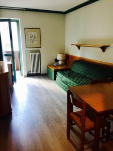 マドンナ・ディ・カンピリオにあるResidence Hotel Sport Campiglioのリビングルーム(緑のソファ、テーブル付)