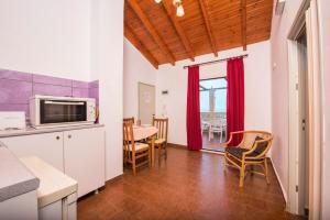 uma cozinha e sala de jantar com mesa e cadeiras em Argo Poolside em Benitses