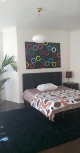 1 dormitorio con 1 cama y una pintura en la pared en Cheap And Chic, en Riga