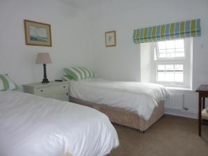 een slaapkamer met 2 bedden en een raam bij The Kestrel B&B in Crickhowell