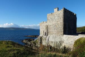 un castillo al borde de un cuerpo de agua en Mingary Castle - Restaurant with Rooms, en Kilchoan