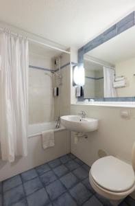 y baño con aseo blanco y lavamanos. en Campanile Saint-Nazaire ~ Trignac, en Trignac