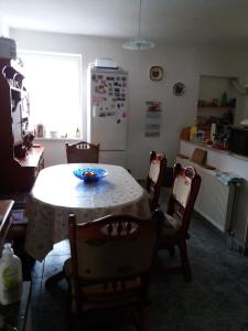 uma cozinha com uma mesa e cadeiras e um frigorífico em Rita vendégház em Villány