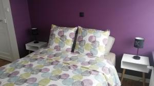 sypialnia z łóżkiem z fioletową ścianą w obiekcie Pause Messines Chez Thérèse w mieście Verlinghem