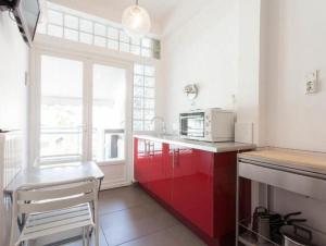 a kitchen with red cabinets and a microwave at Acropolis charming apt with large balcony - DM17 in Athens