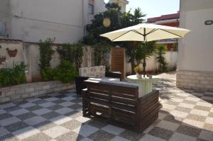a patio with a table and an umbrella at Biblos e Mare in Taranto