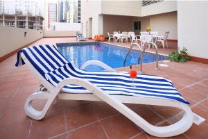 a lounge chair sitting next to a swimming pool at Aspire Tower in Manama
