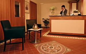 a woman standing at a podium in a waiting room at Hotel Alte Bäckerei in Nidderau