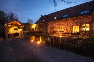 une maison avec des lumières devant elle la nuit dans l'établissement Sparhof, à Dranoutre