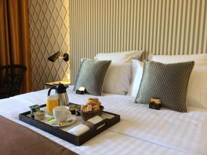 a tray of food and drinks on a bed at Aquabella Hôtel & Spa in Aix-en-Provence