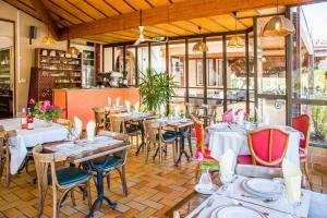 a restaurant with tables and chairs in a room at Hostellerie de La Roseraie in Barbotan-les-Thermes