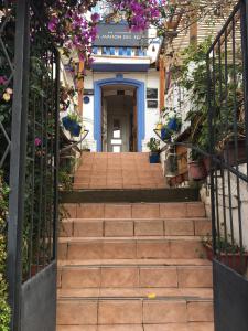 eine Treppe, die zu einem Gebäude mit lila Blumen führt in der Unterkunft La Maison des Fous in Papudo