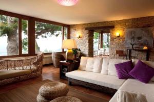 ein Wohnzimmer mit einem Sofa und einigen Fenstern in der Unterkunft La Casa de la Abuela Milagros in Pravia