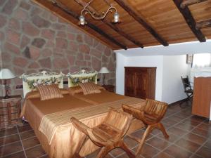 CañeteにあるApartamentos Rurales La Muralla IIのベッドルーム1室(大型ベッド1台、椅子2脚付)