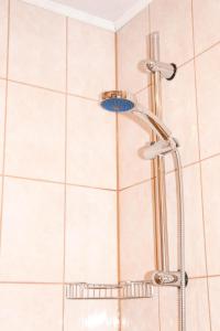 a shower head in a bathroom with white tiles at Viktoria Apartment in Narva