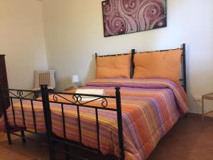 ファヴィニャーナにあるVilla Favonioのベッドルーム1室(オレンジ色の掛け布団付きのベッド1台付)