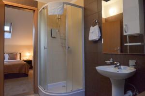 a bathroom with a shower, sink, and toilet at Garni Hotel Ema in Kragujevac