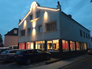 un edificio blanco con coches estacionados frente a él en Hotel Sophia, en Warendorf