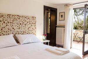 a bedroom with a white bed and a window at Casa Corvina in Verona