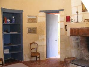 a room with a door and a chair and a fireplace at La chambre de la Tour in Lugon et l’Ile du Carney