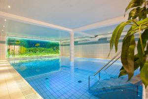 an indoor swimming pool with an aquarium in a house at Hotel Hesborner Kuckuck in Hallenberg