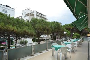 une rangée de tables et de chaises sur un balcon dans l'établissement Hotel Europa, à Rimini