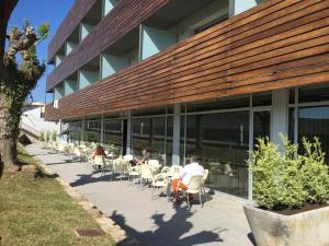 a group of people sitting at tables outside of a building at Hotel Balneario de Gravalos in Grávalos