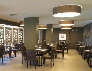 a dining room with tables and chairs and a chandelier at Hotel Balneario de Gravalos in Grávalos
