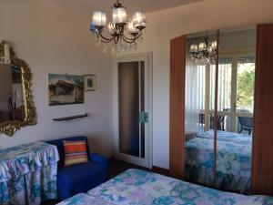 1 Schlafzimmer mit 2 Betten, einem Spiegel und einem Kronleuchter in der Unterkunft Bruseschi in Grado