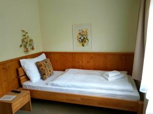 Cama pequeña en habitación con marco de madera en Hotel Tauplitzerhof en Tauplitz