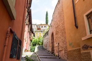 an alleyway between two buildings with stairs going up them at Casa Corvina in Verona